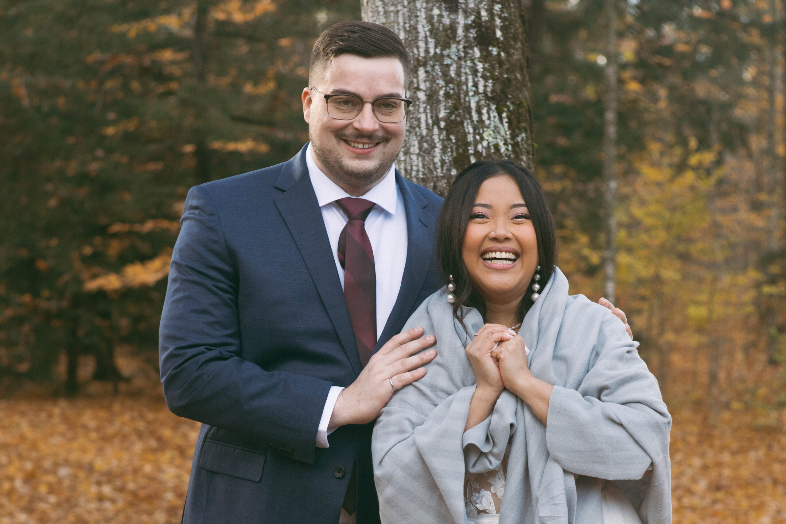 The bride and groom share a joyful laugh during their formal photos on a chilly, rainy day at the Tiffin Centre for Conservation.